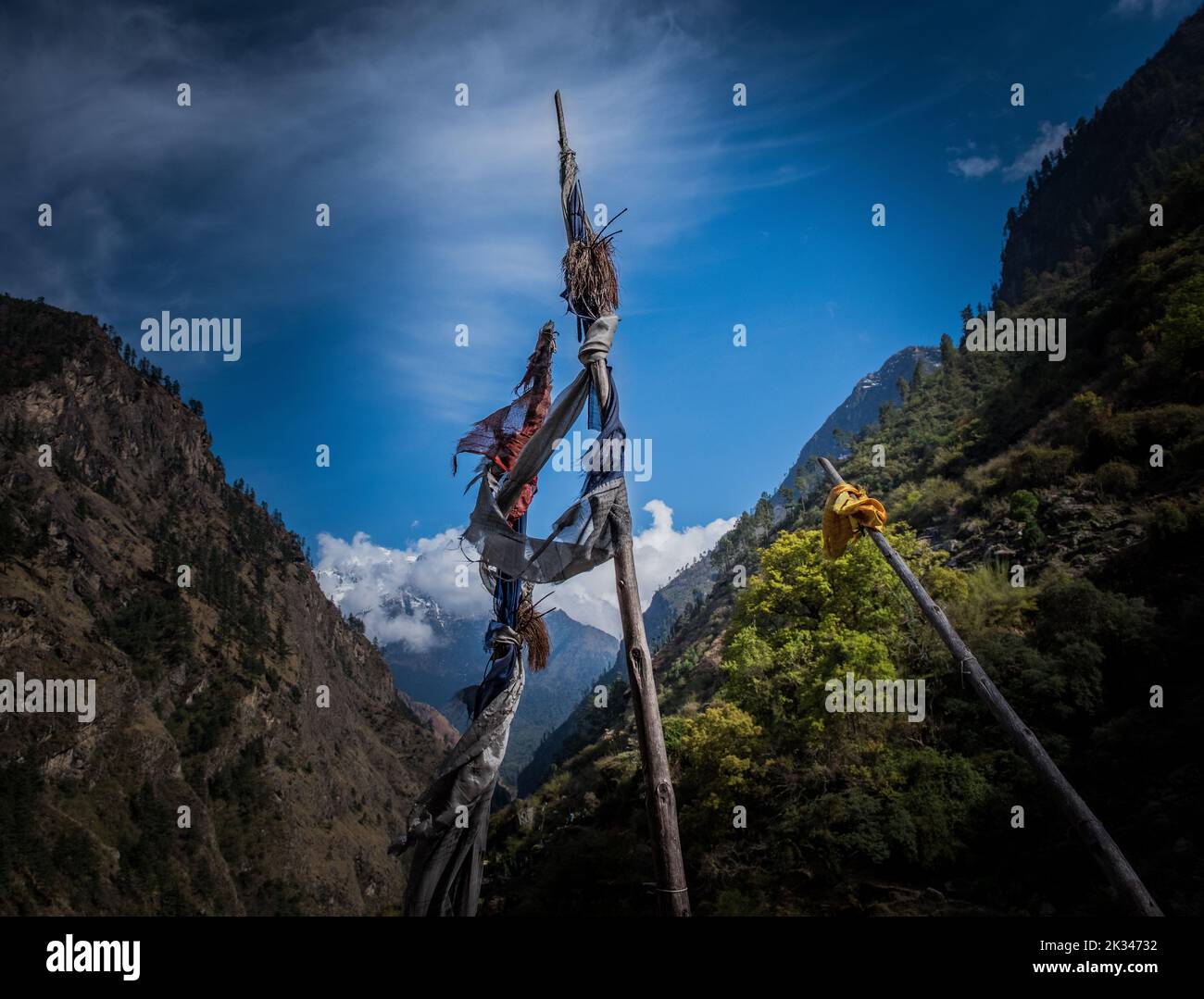 Prayer flags on poles in a mountain valley on the Manaslu Circuit. Stock Photo