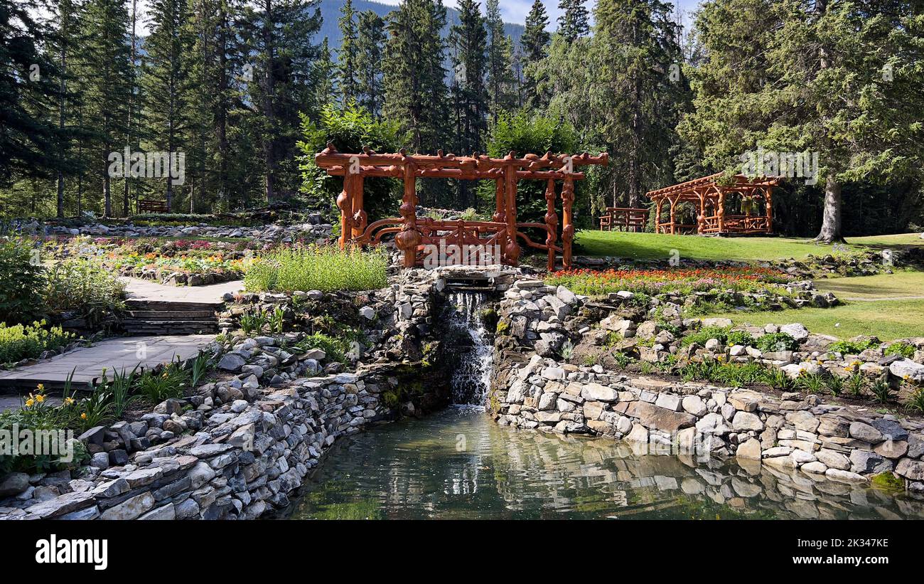 The wooden gazebos with a pond surrounded by green vegetation. Cascade