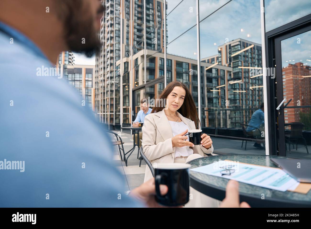 Female entrepreneur talking to her colleague during coffee break Stock Photo