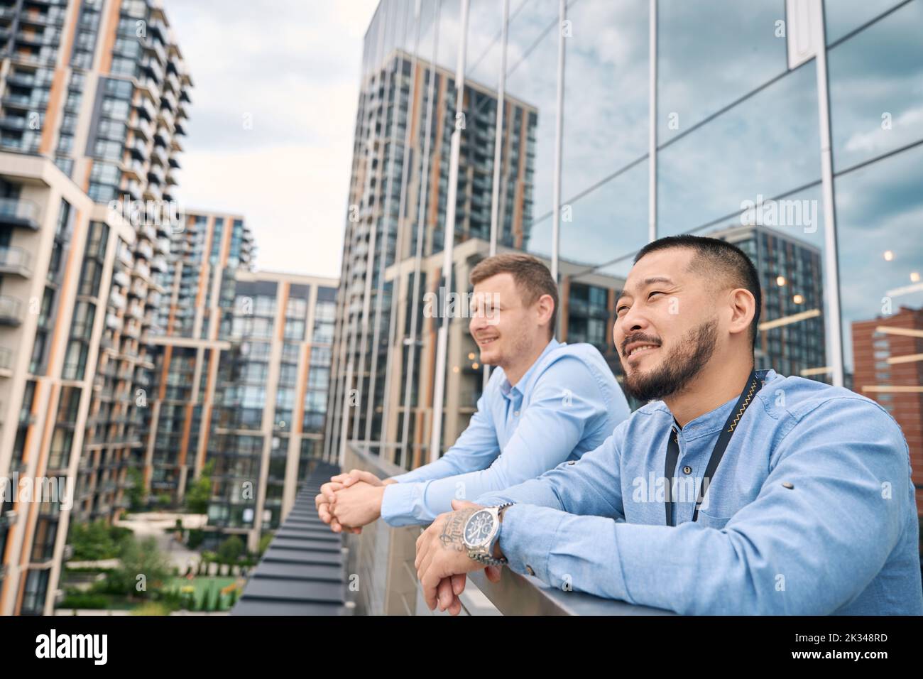 Company worker and his coworker resting on office balcony Stock Photo