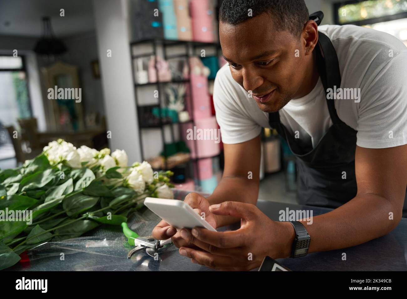 Florist looks at the phone near the bouquet Stock Photo