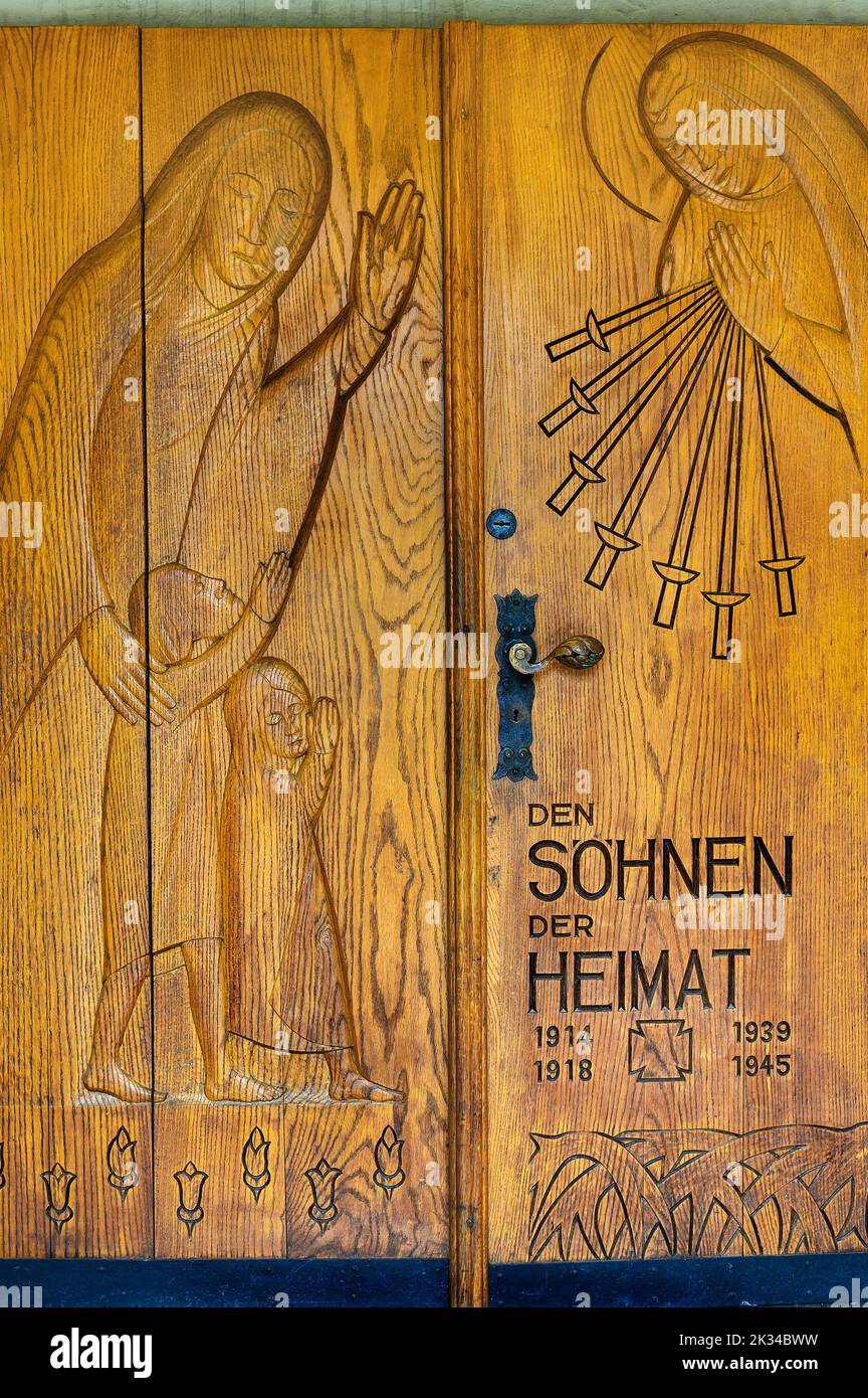 Wooden gate with relief acts as war memorial, Church of St. Alexander and Georg, Niedersonthofen, Allgaeu, Bavaria, Germany Stock Photo