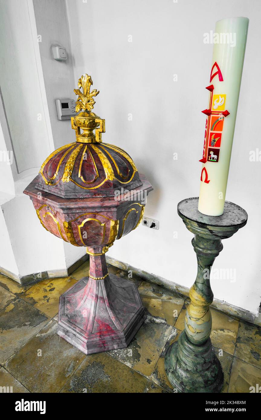 Baptismal font and candle, Church of St. Anna in Betzigau, Allgaeu, Bavaria, Germany Stock Photo