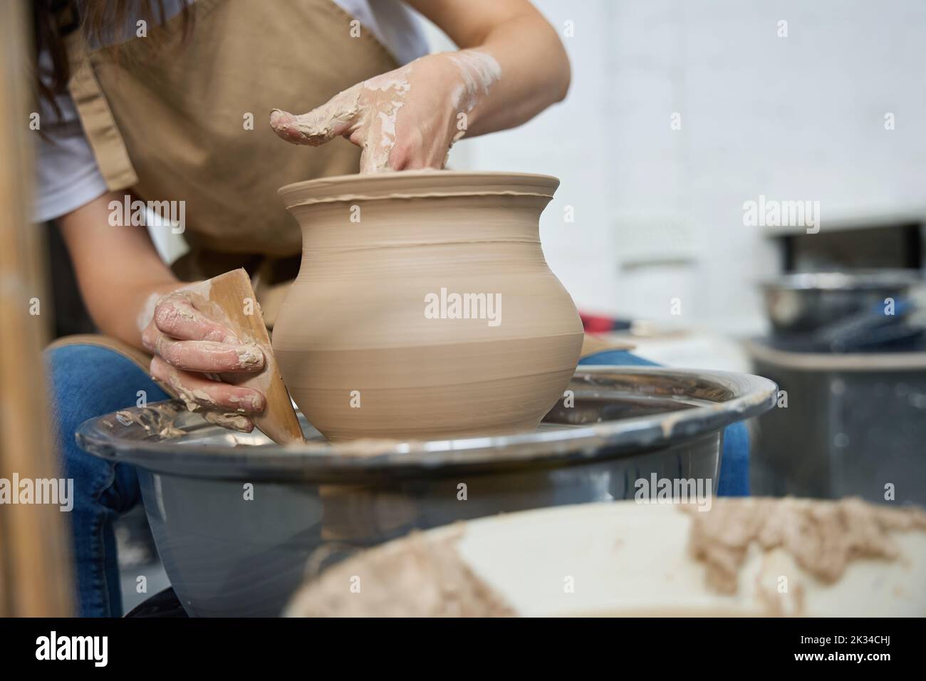 Woman potter forms earthenware on a potter wheel Stock Photo