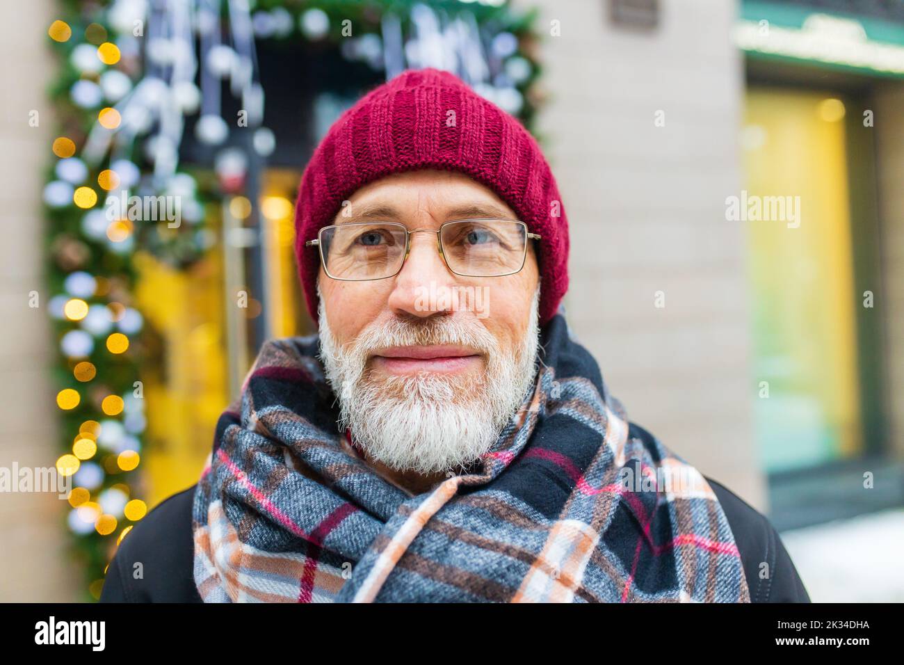 trendy old good-looking man walking in sity street at winter near modern building Stock Photo