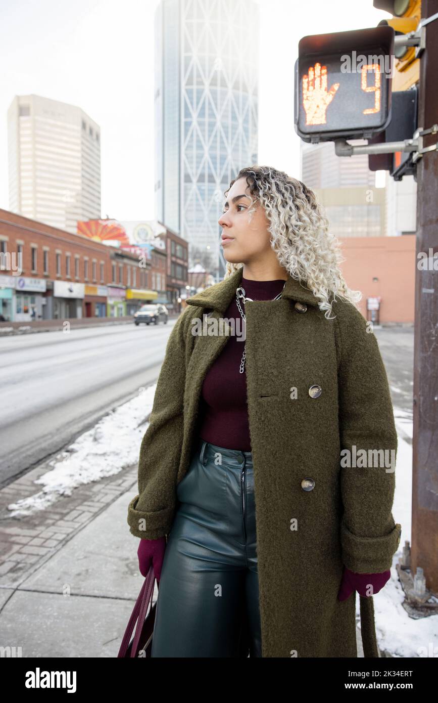 Beautiful stylish young woman on winter city street corner Stock Photo
