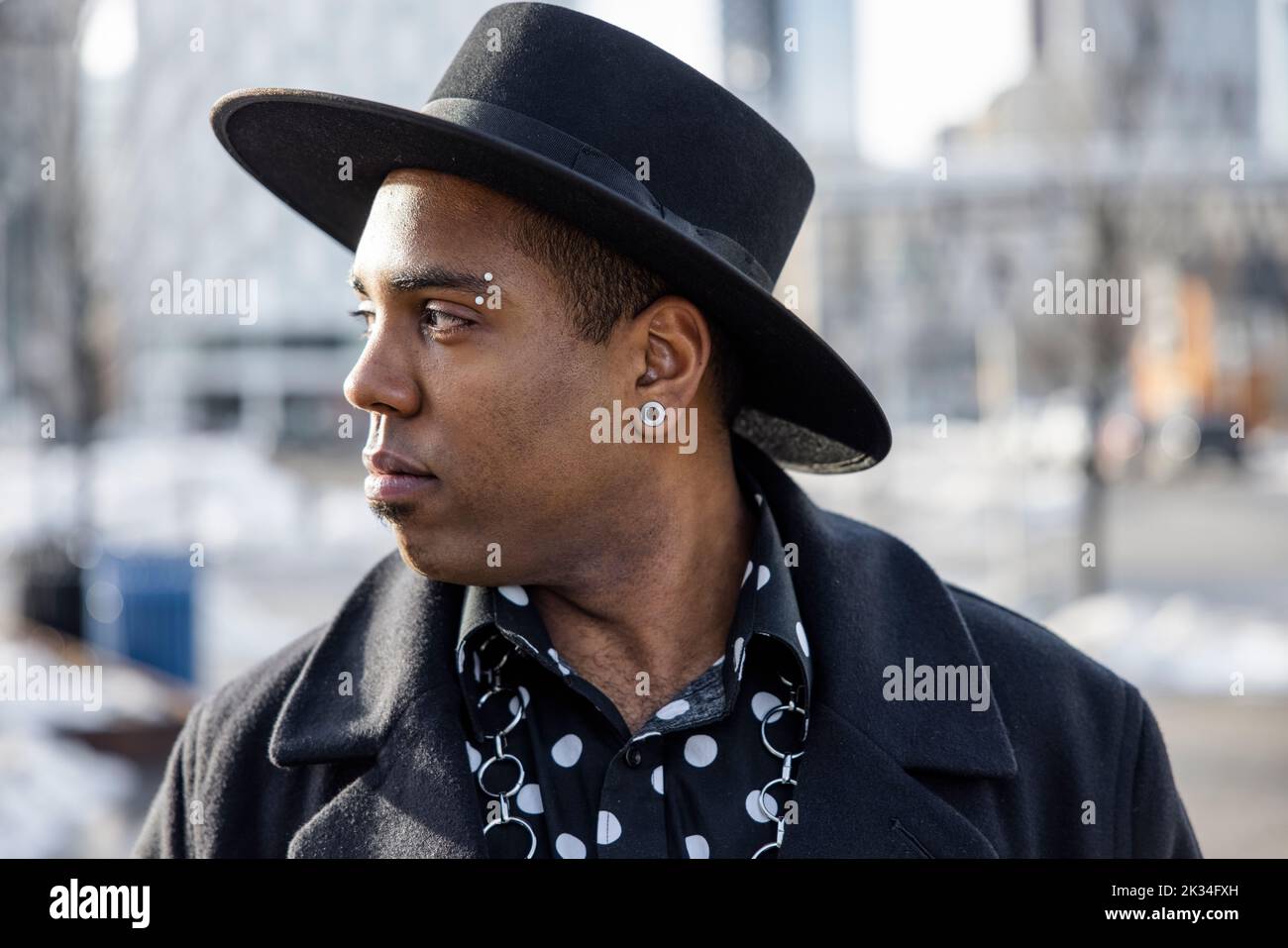 Portrait stylish handsome young man in fedora with pierced brow Stock Photo