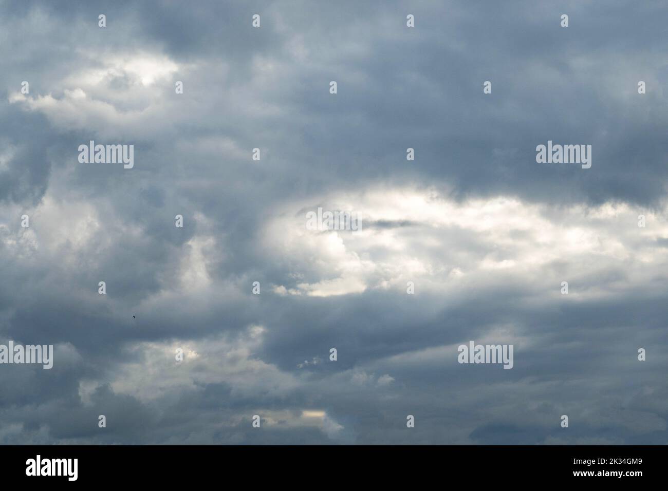 Cumulus nimbus clouds with the sun peeking through Stock Photo