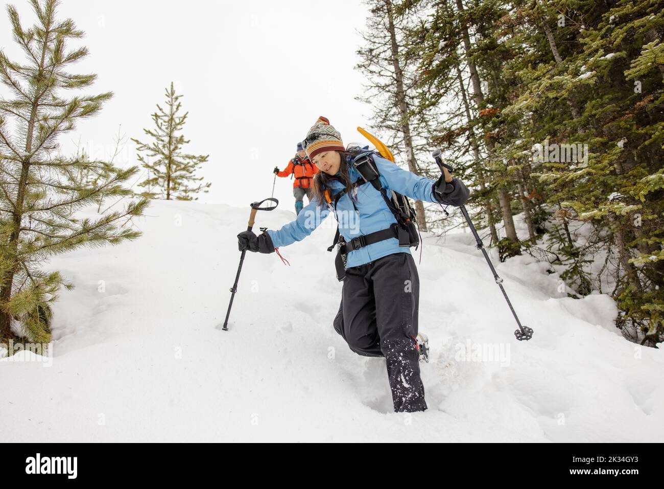Woman snowshoeing down deep snowy slope Stock Photo Alamy