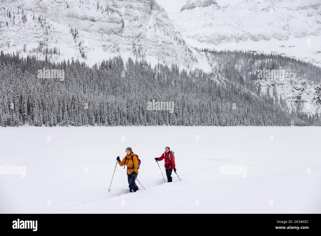 Friends cross country skiing below snowy Canadian Rocky Mountains Stock Photo