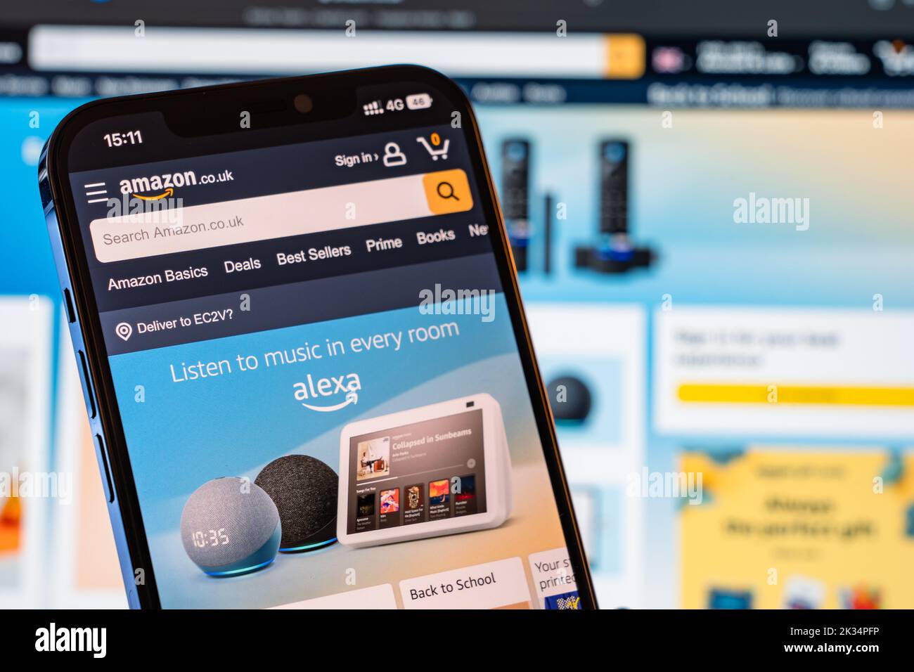 Amazon Mobile Website with laptop website in the background Stock Photo