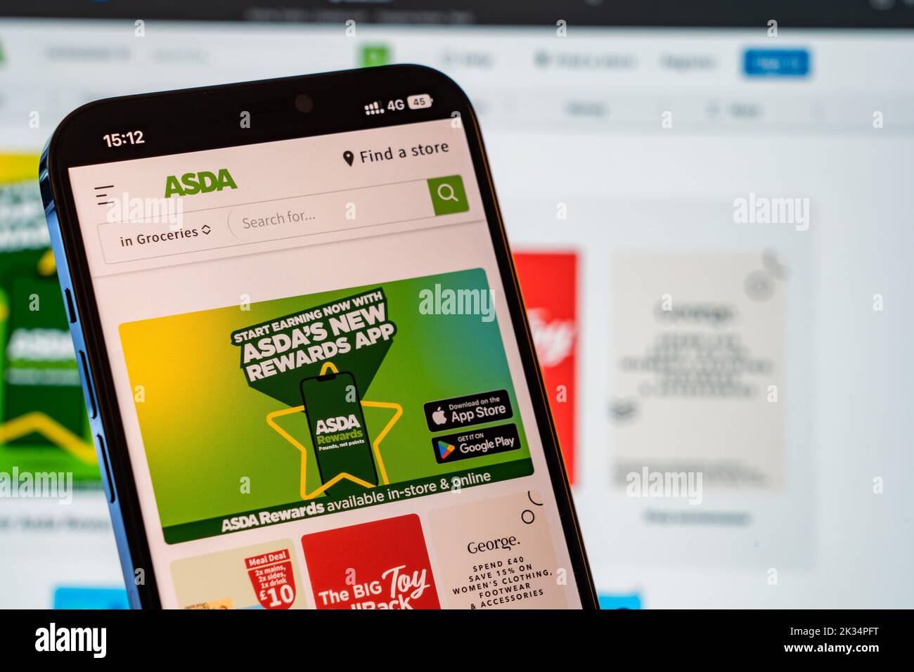 Asda Mobile Website with laptop website in the background Stock Photo
