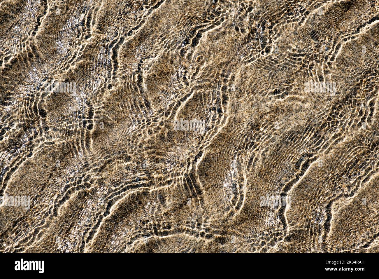 Ripples in the ocean at low tide creating patterns in the sand, Cornwall, England. Stock Photo