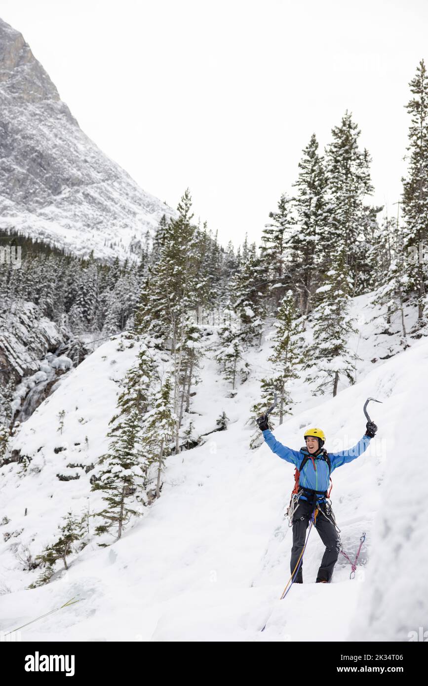 Ice climber rejoicing on snowy mountain Stock Photo