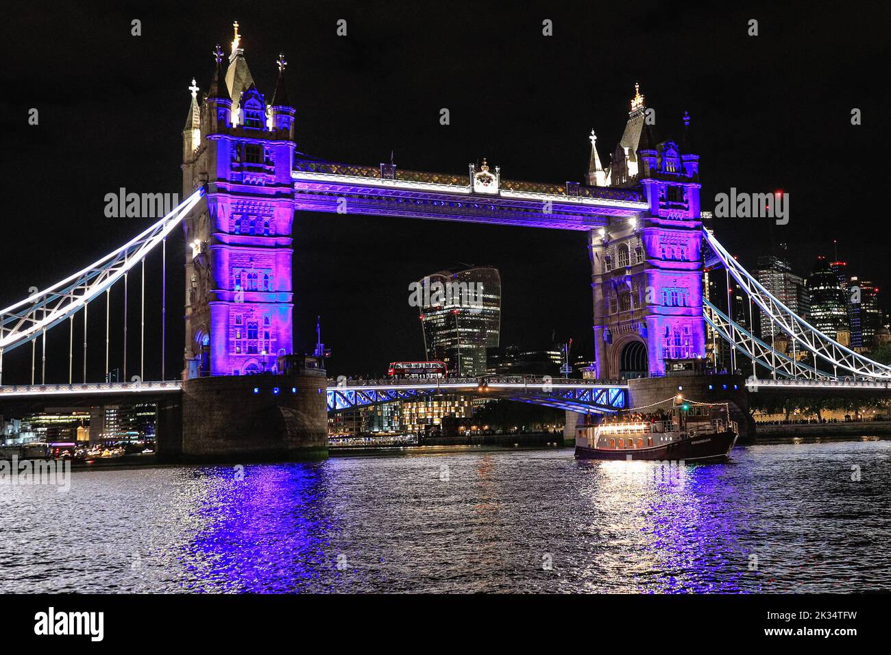 London, UK, 24th Sep 2022. The flotilla reaches Tower Bridge, illuminated in purple as a tribute to the Queen. Reflections, a night-time flotilla, on the River Thames in London, marks the passing of Her Majesty the Queen and the accession of King Charles III. Part of Totally Thames, the illuminated flotilla travels from Chelsea Bridge to Tower Bridge, with the Queen's row barge Gloriana, as its centrepiece. Credit: Imageplotter/Alamy Live News Stock Photo