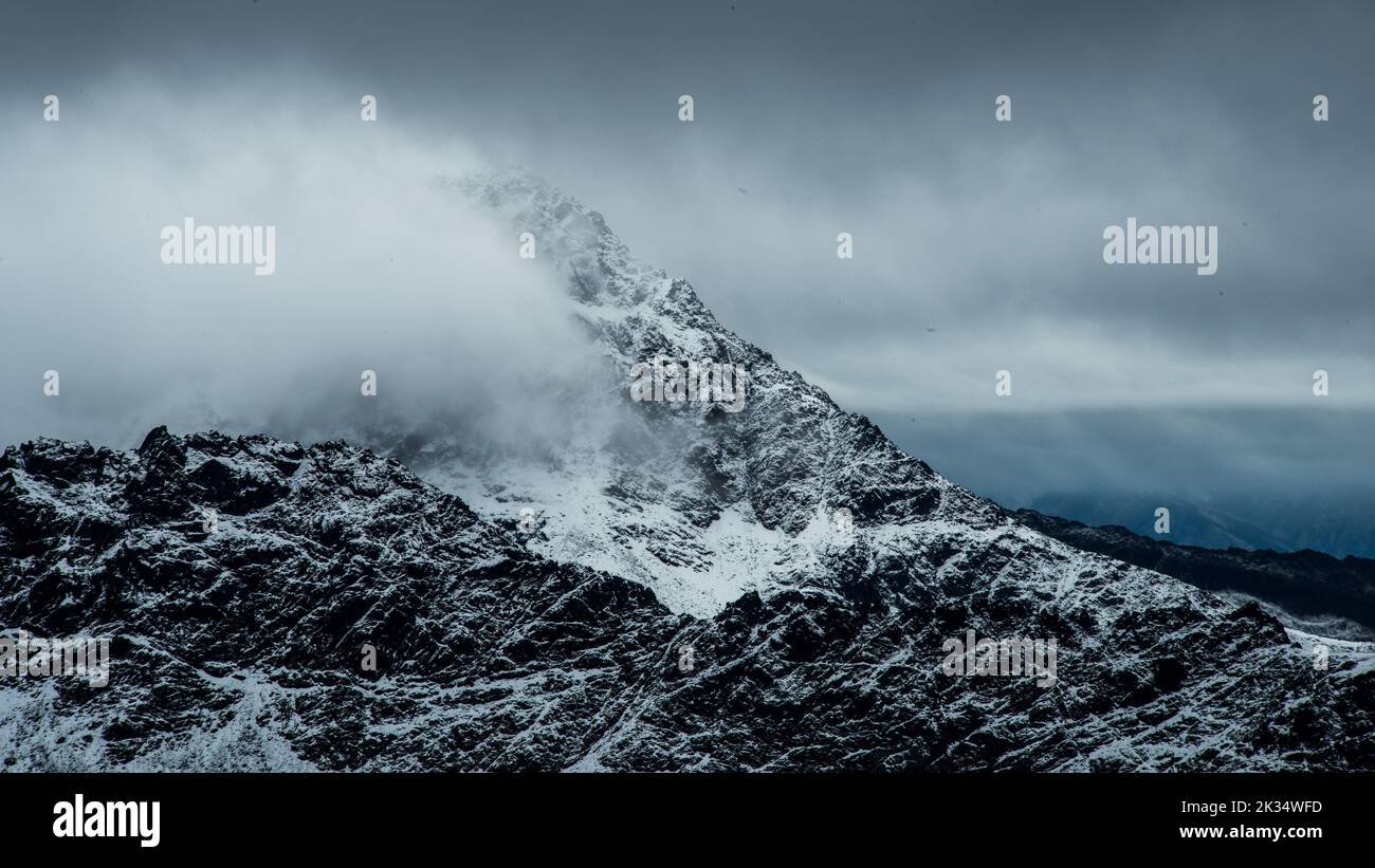 The high rocky mountains touching the clouds on a foggy day Stock Photo ...