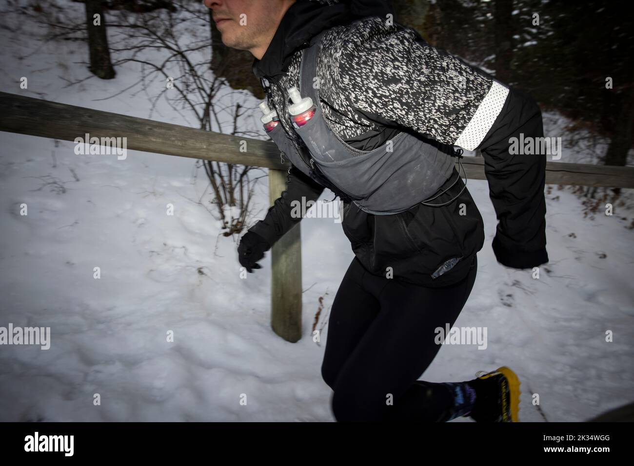 Male runner moving up snow covered steps Stock Photo