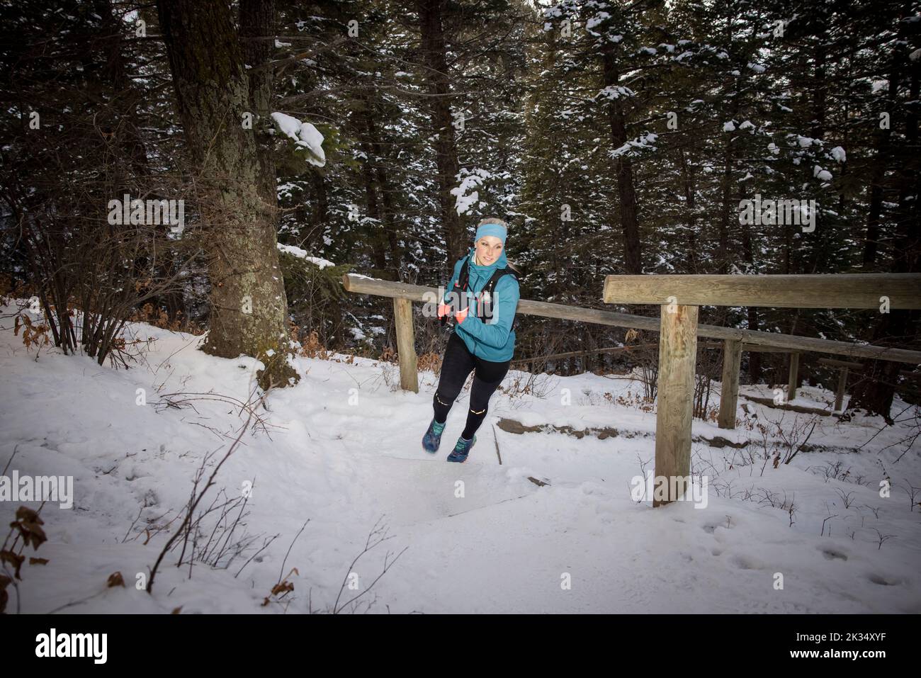 Female runner moving up snow covered steps Stock Photo