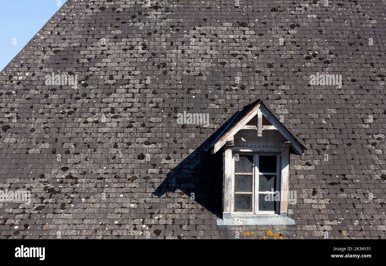 View of an old small Dormer Window in stone roof of Navarrenx Stock Photo