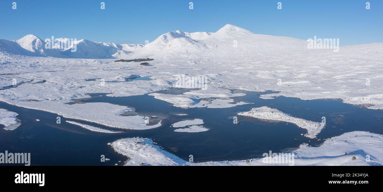 Stunning aerial drone Winter landscape images of Loch Ba and snow covered mountains in background in Scottish Highlands Stock Photo