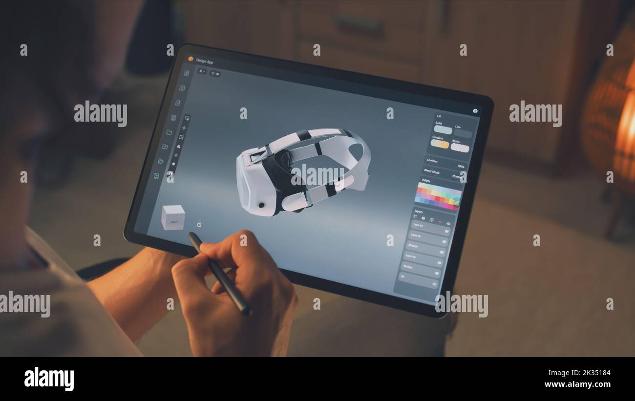 Young male 3D designer drawing and creating 3D prototype of VR headset in professional design application on tablet using digital pencil Stock Photo