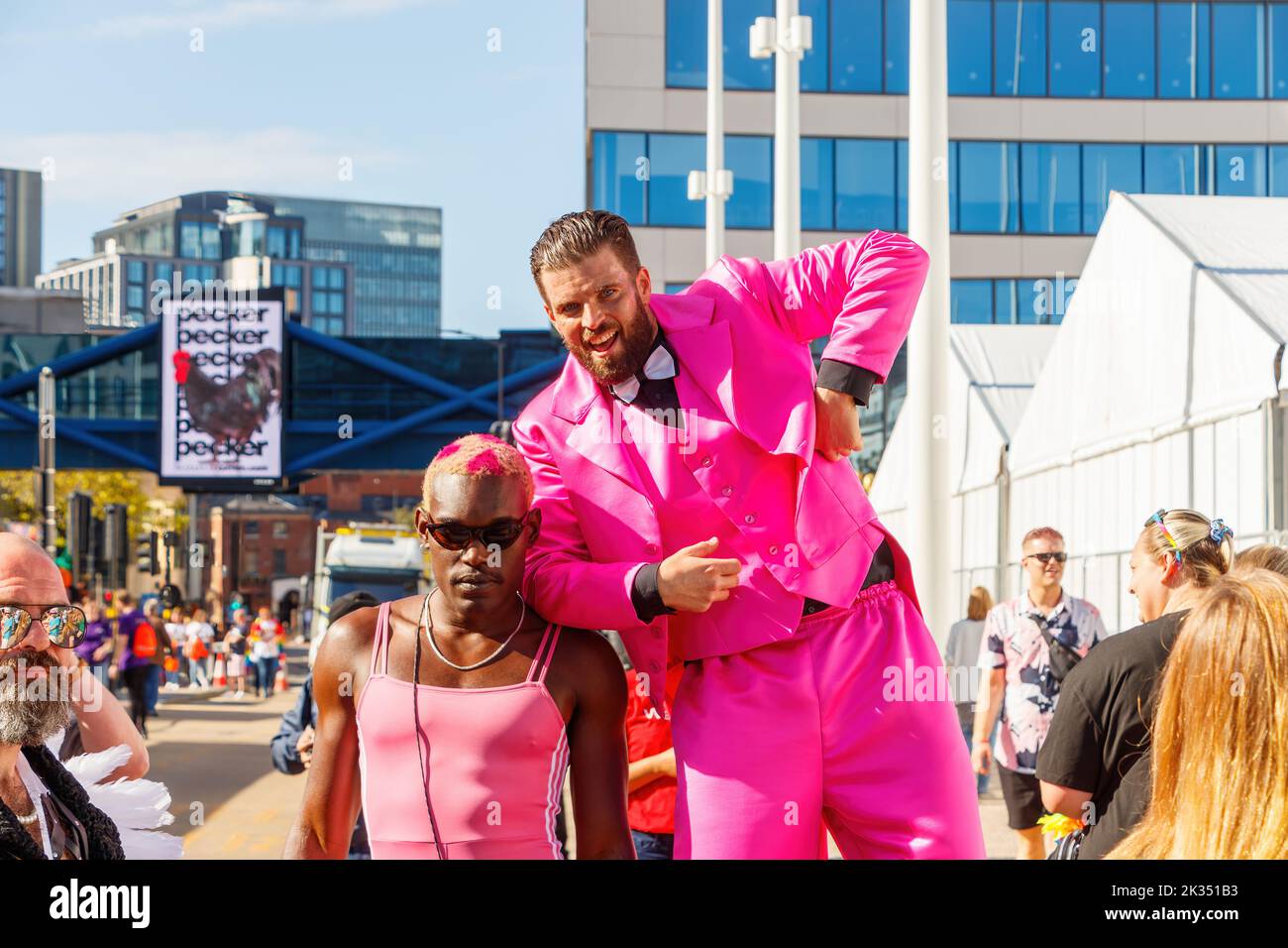 black skinned man wearing pink leotard with bearded man in suit on stilts Gay Pride parade protest 2022 in birmingham city centre uk september 24th Stock Photo