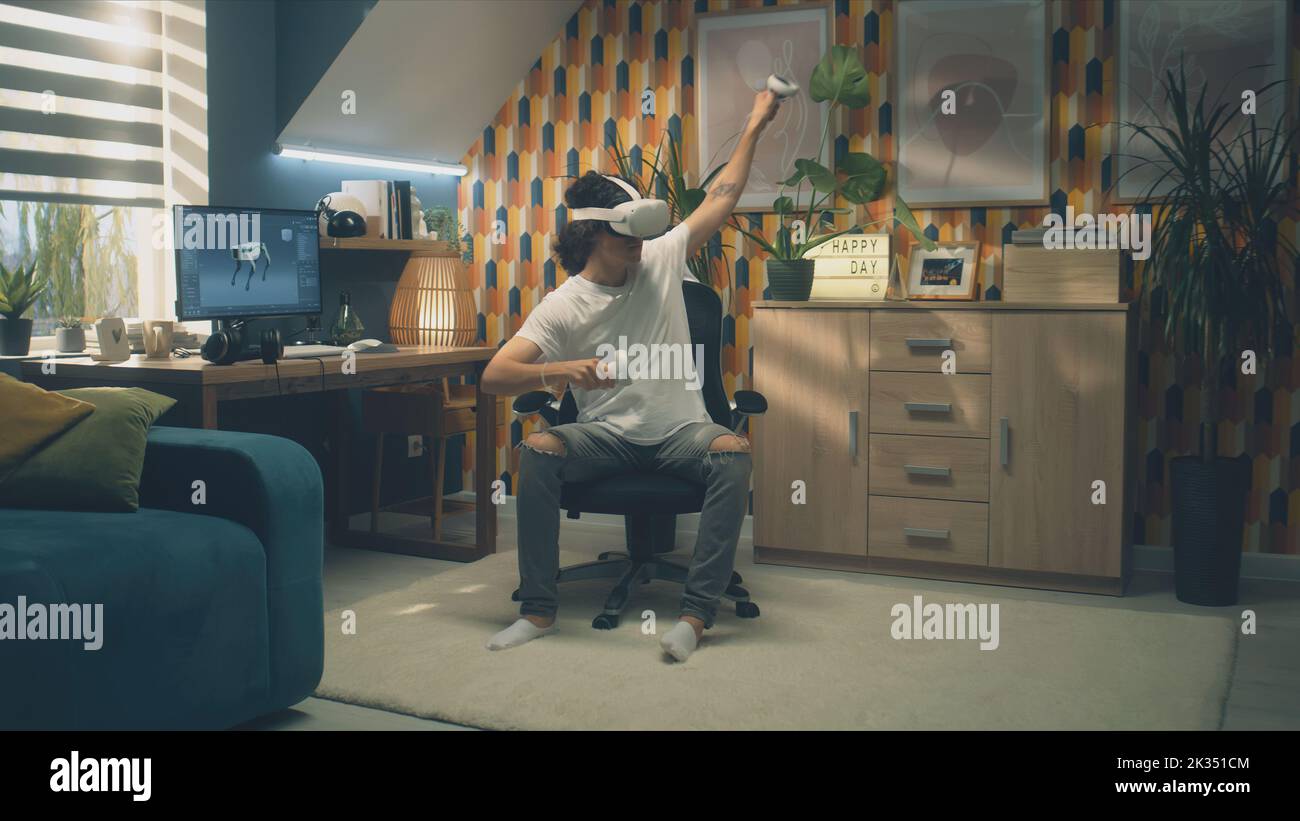 Man playing video game using modern VR headset and wireless controllers ...