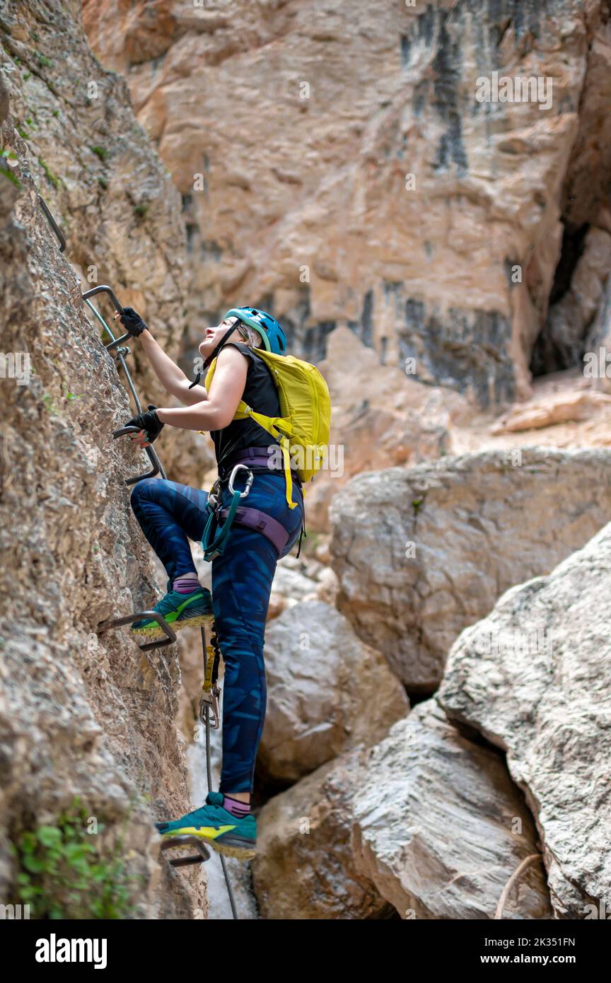 Beautiful woman climbing on via ferrata trail Stock Photo