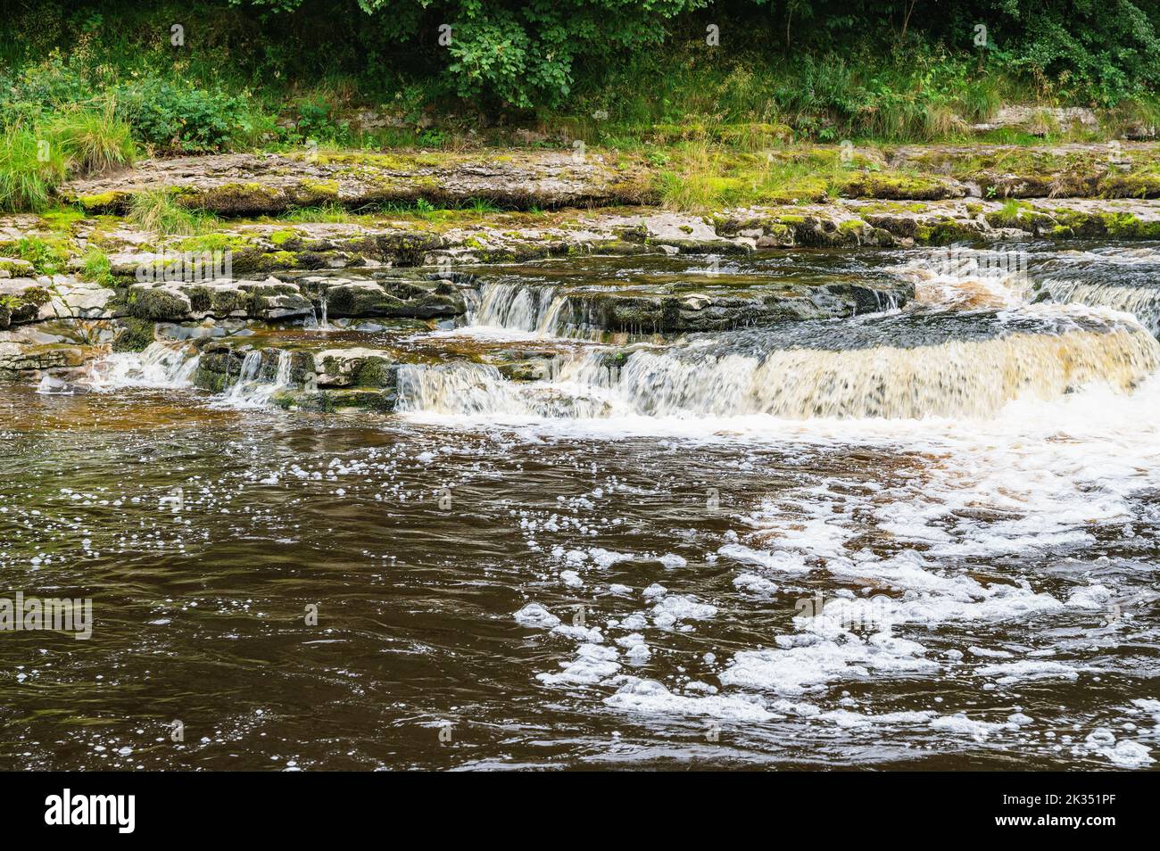 Aysgarth Falls are a three levels one mile stretch waterfalls in Yorkshire Dales National Park, River Ure, Northern England. Long exposure effect photo, selective focus Stock Photo