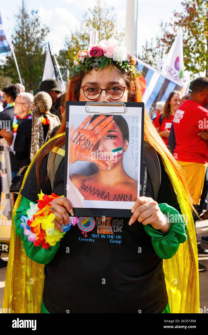 woman with sign placard against iran death mahsa amini  Gay Pride parade protest 2022 in Birmingham city centre uk september 24th Stock Photo