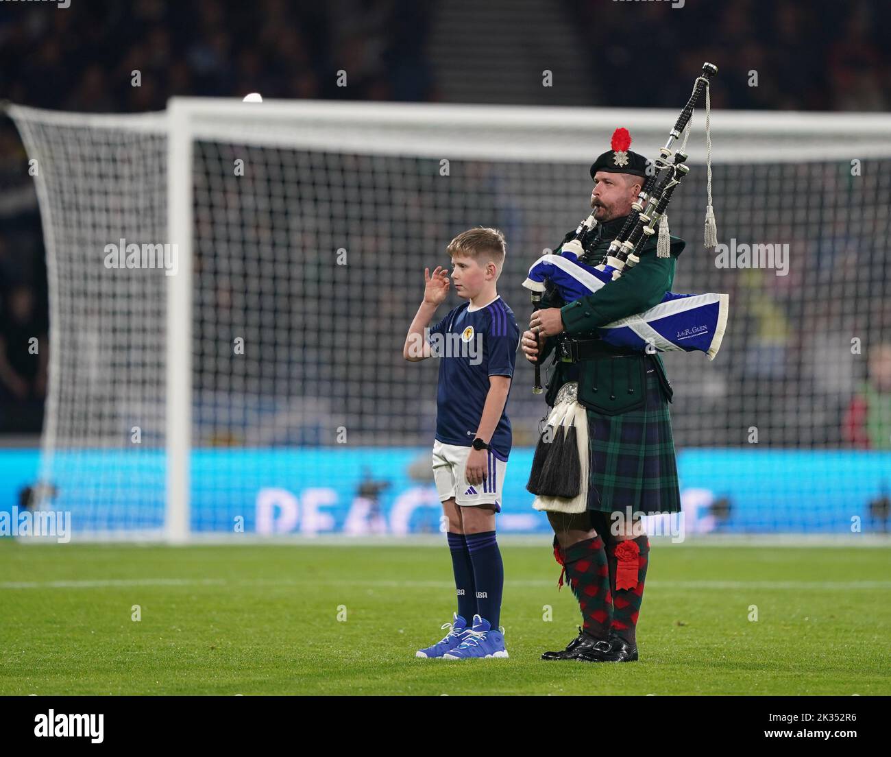 A pipe player and a boy using sign language during the national anthem before the UEFA Nations League Group E Match at Hampden Park, Glasgow. Picture date: Saturday September 24, 2022. Stock Photo