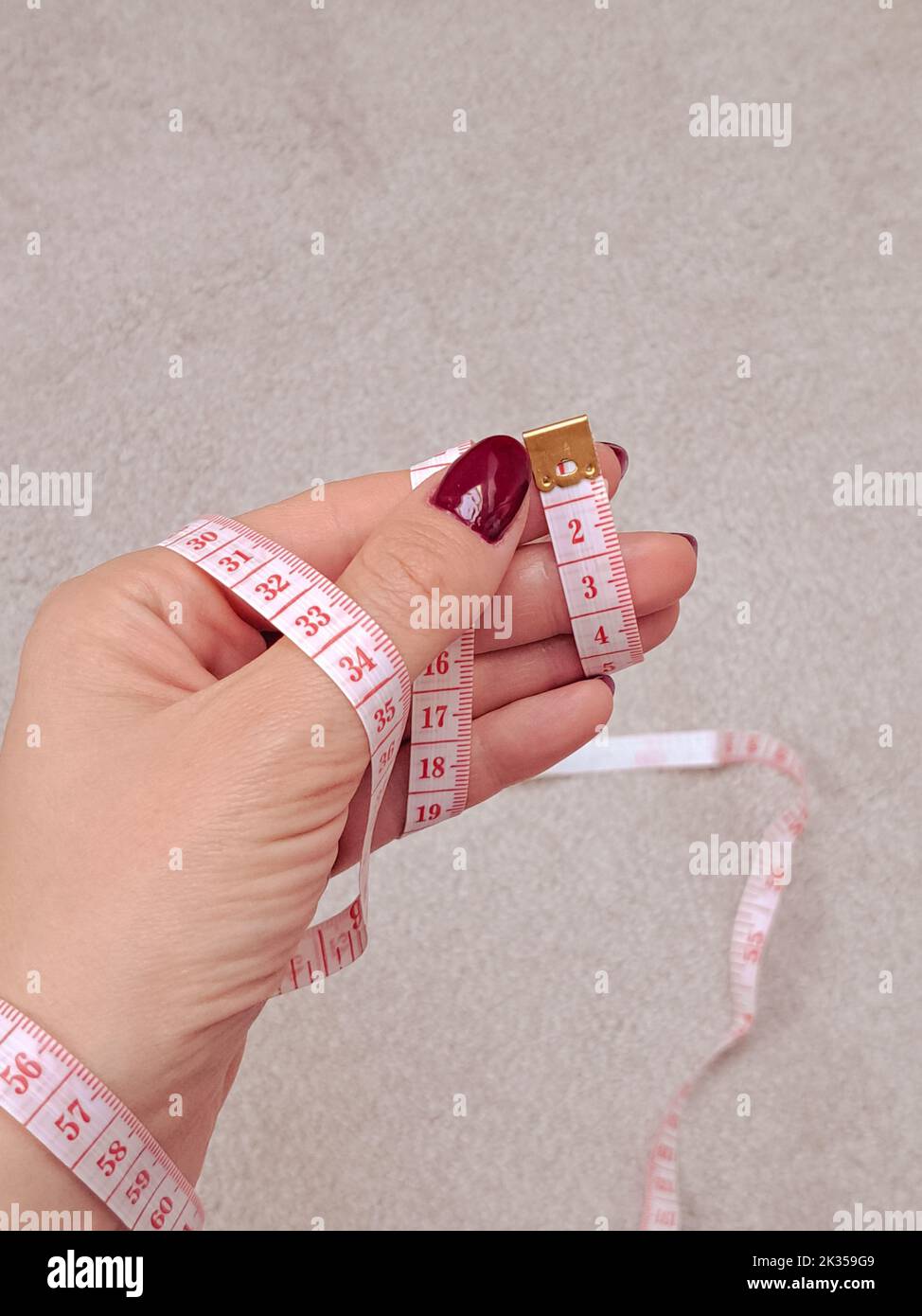 Close up of measure tape in hand copy space Stock Photo