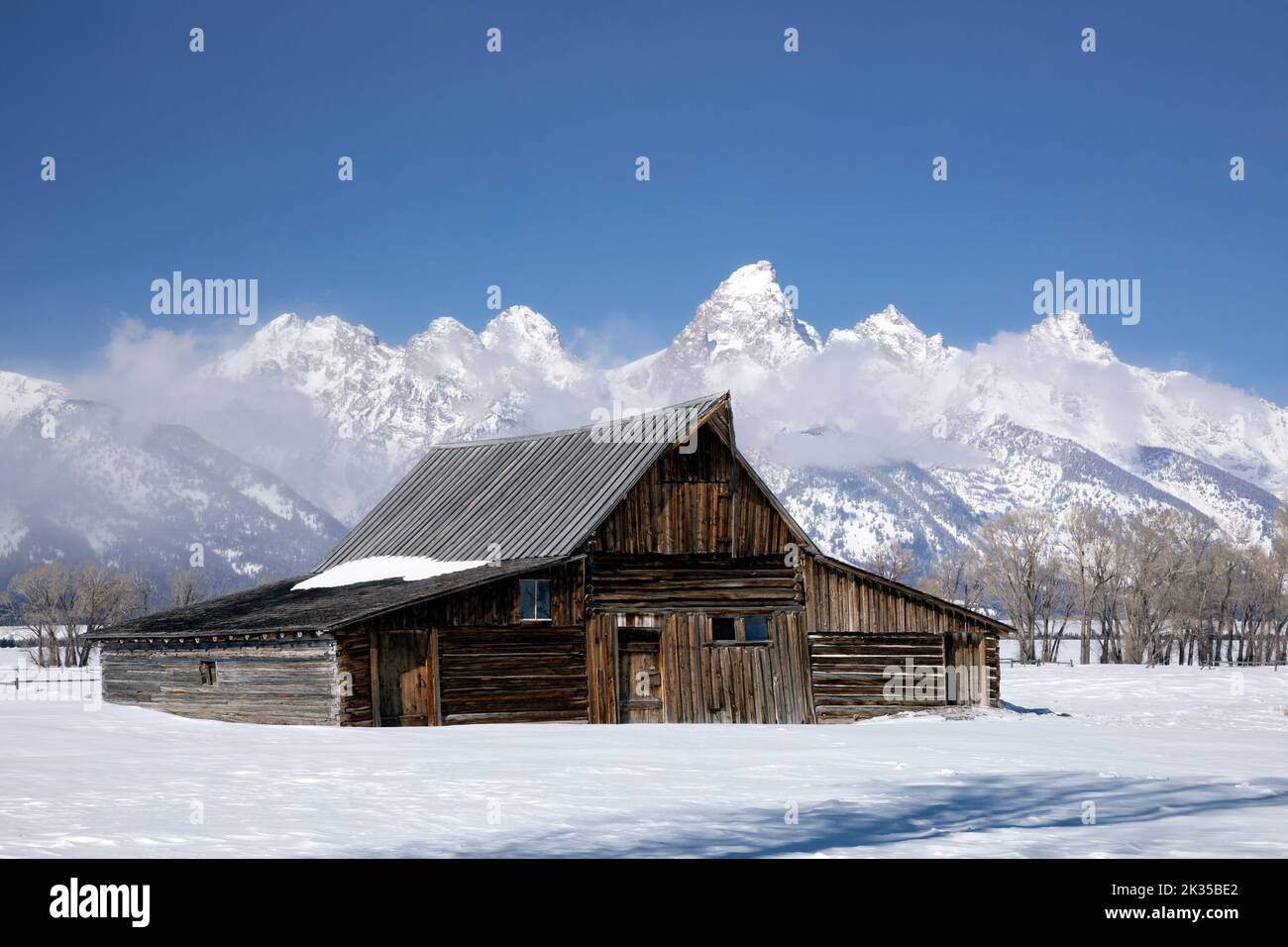 WY05068-00.....WYOMING - Barn in the Mormon Row Historic District with the Teton Range in winter, Grand Teton National Park. Stock Photo