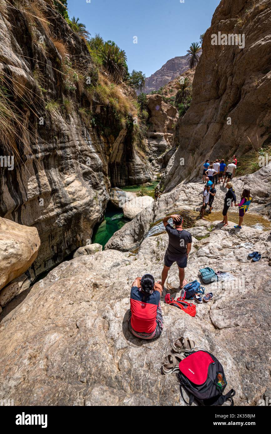 Tourists ready to climb Wadi Tiwi gorge, Oman Stock Photo