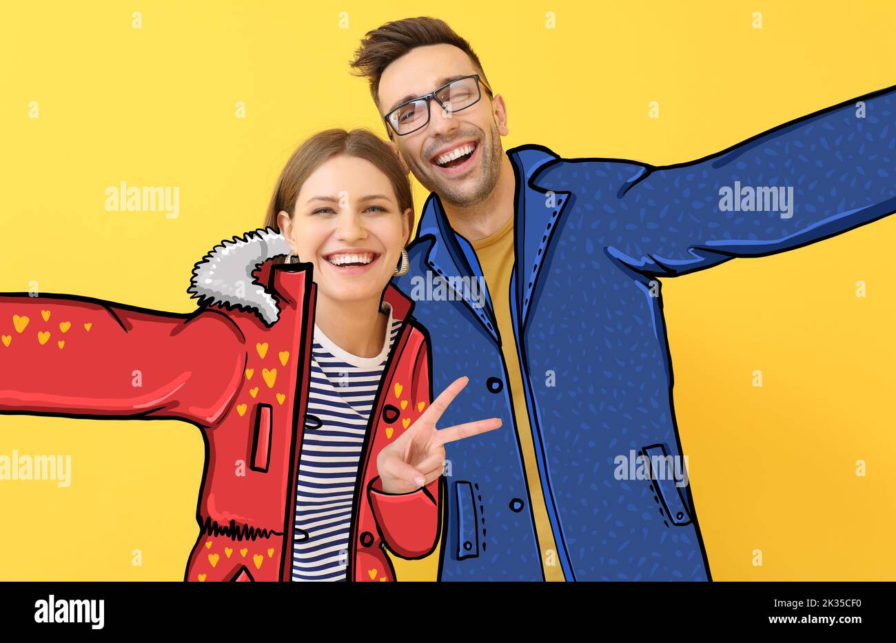 Happy young couple in stylish drawn coats taking selfie on yellow background Stock Photo
