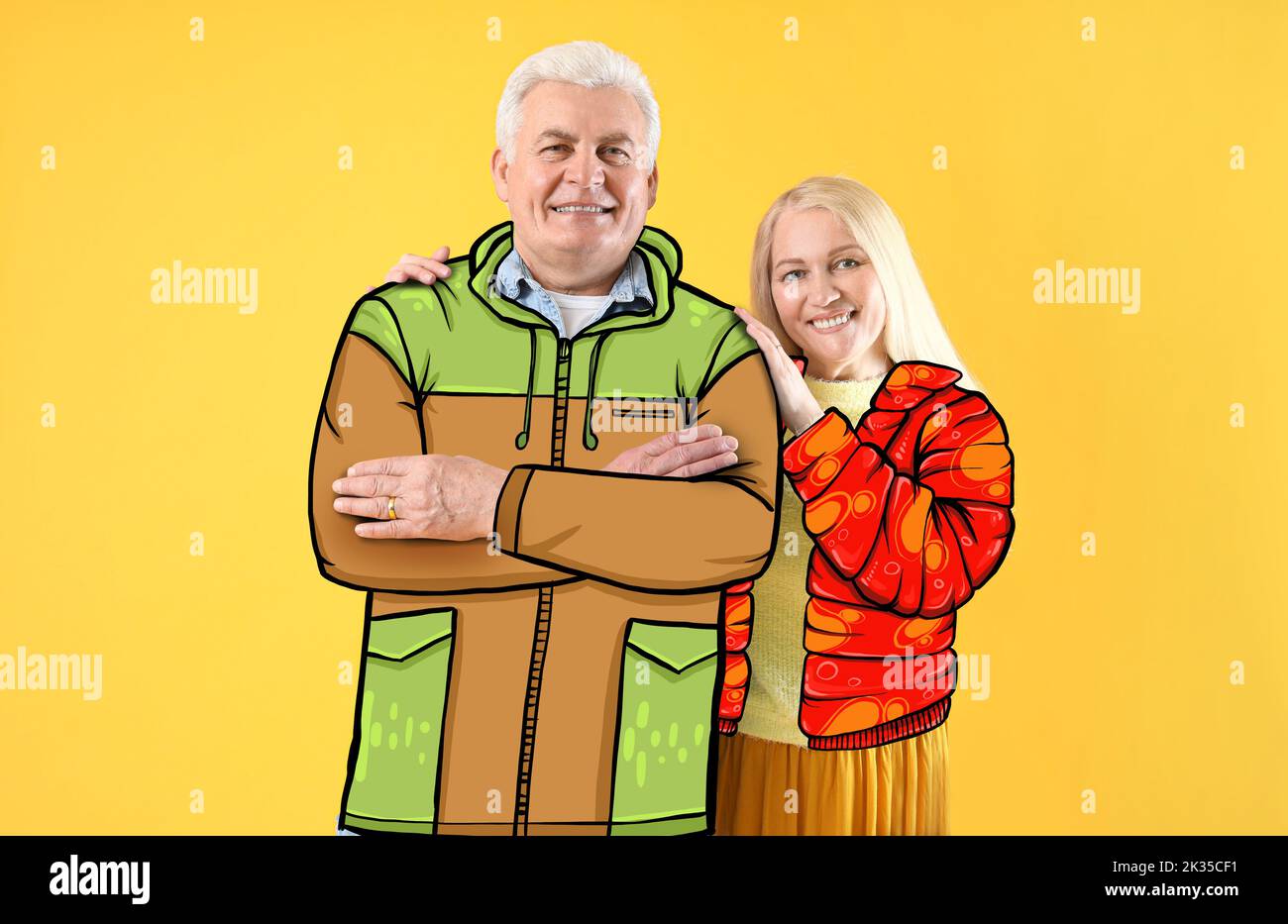 Happy elderly couple in stylish drawn coats on yellow background Stock Photo