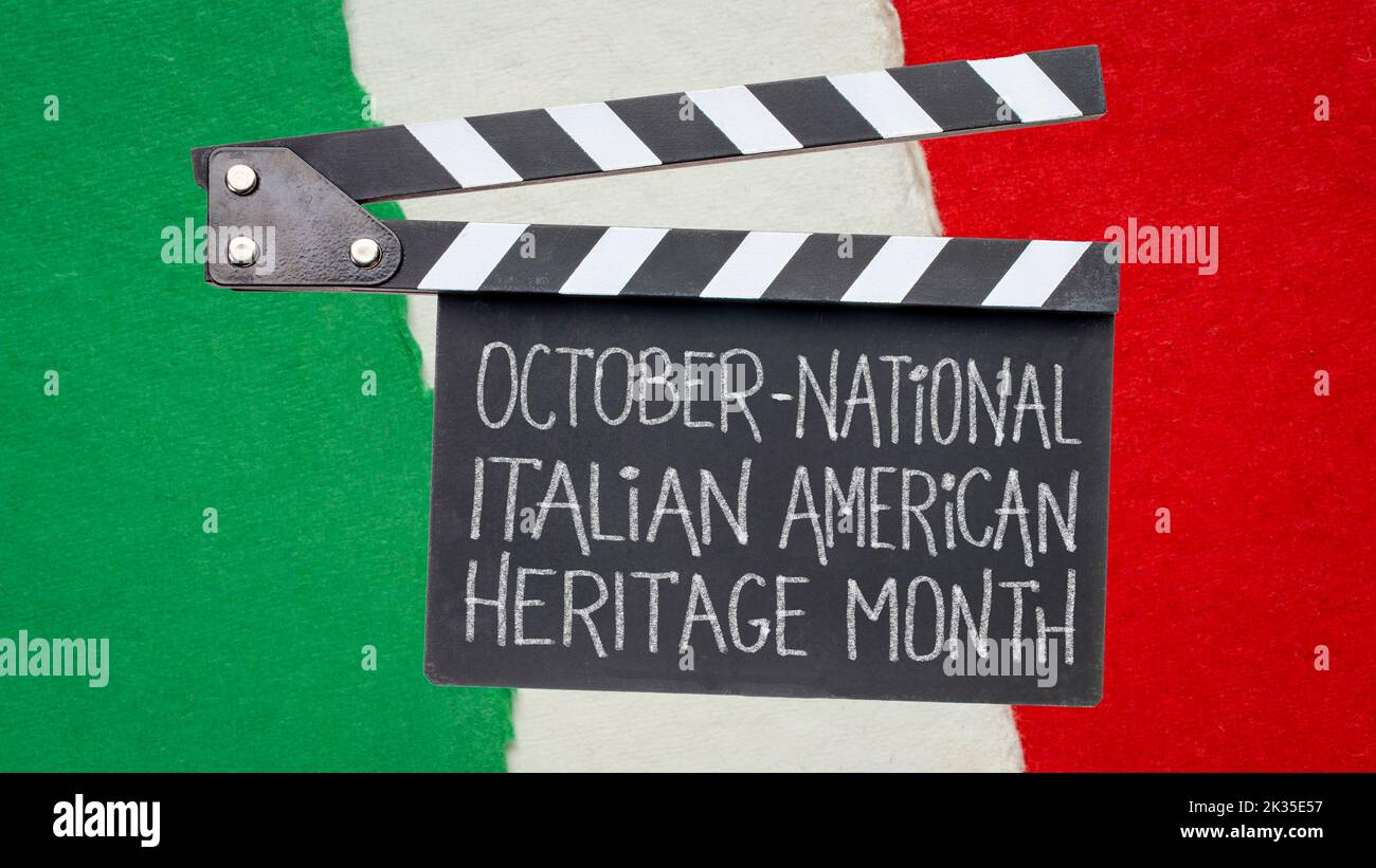 October - National Italian American Heritage Month, white chalk handwriting ion a clapboard  against paper abstract in colors of national flag of Ital Stock Photo