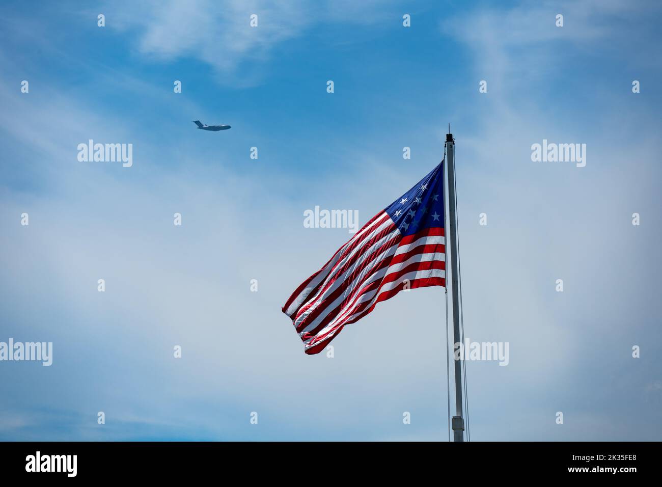 Star Spangled Banner flag flying over Fort Moultrie flag with a Charleston C-17 flying in the background Stock Photo