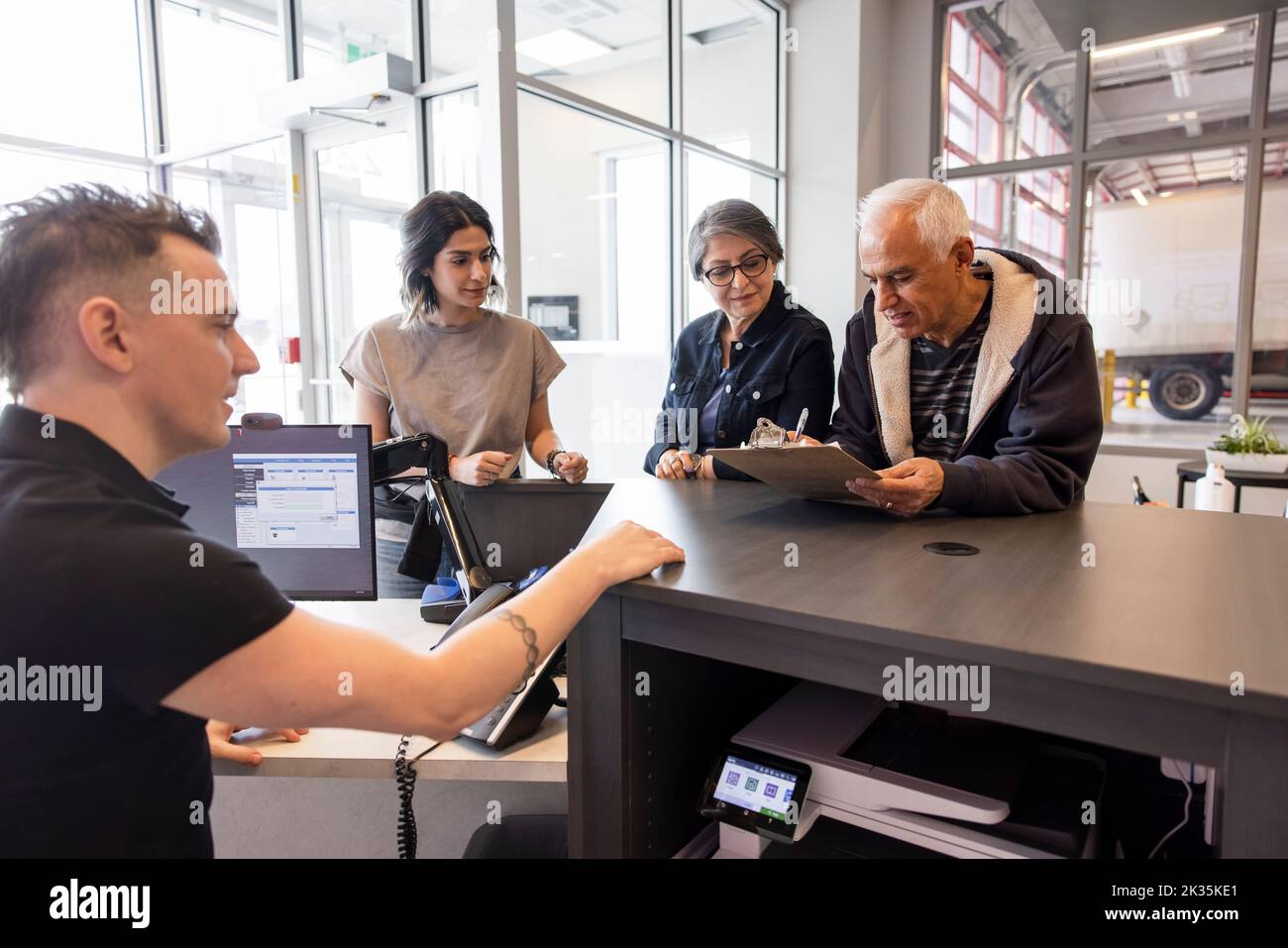 Storage facility worker helping family at front desk Stock Photo Alamy