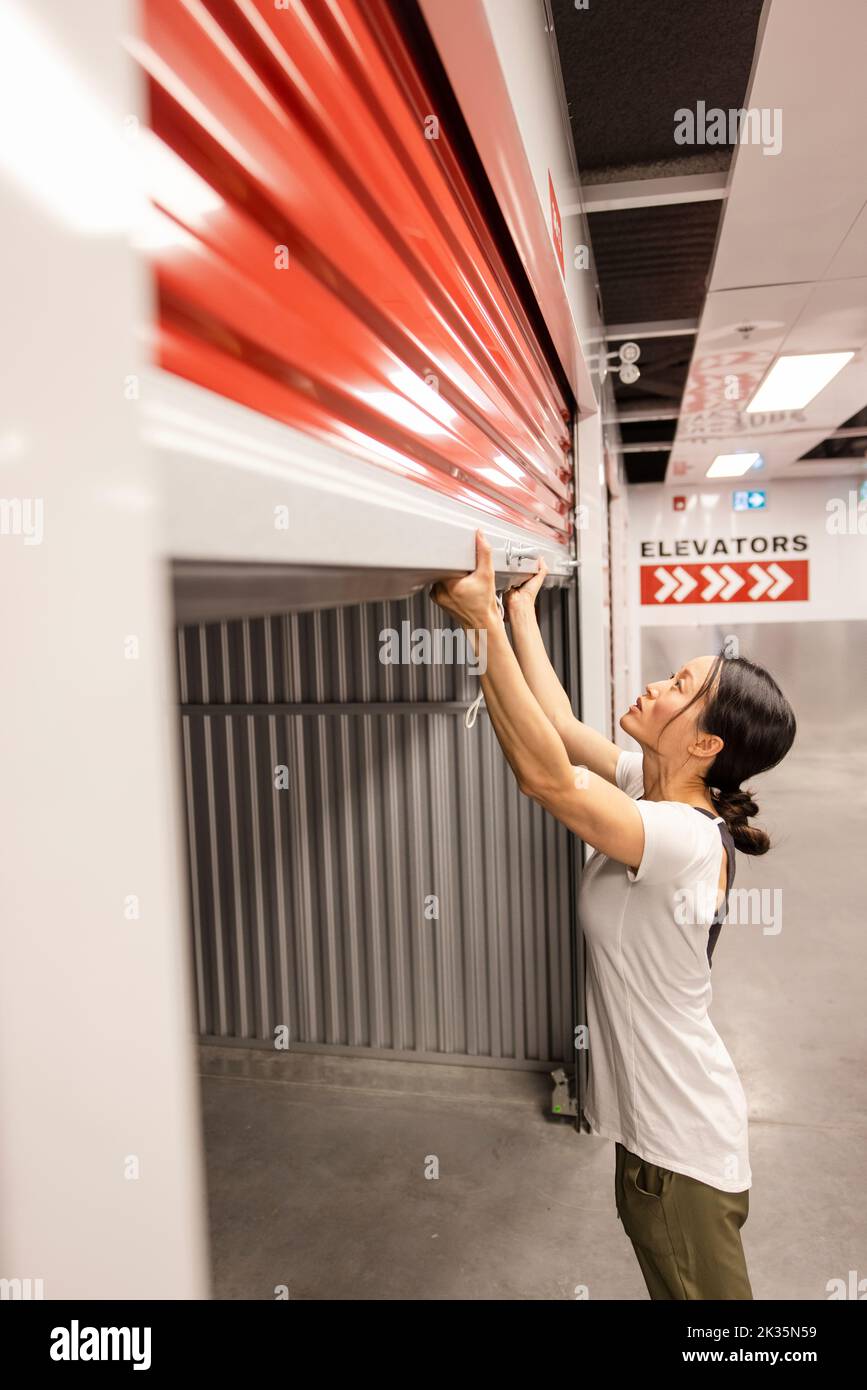 Woman opening storage facility locker Stock Photo Alamy