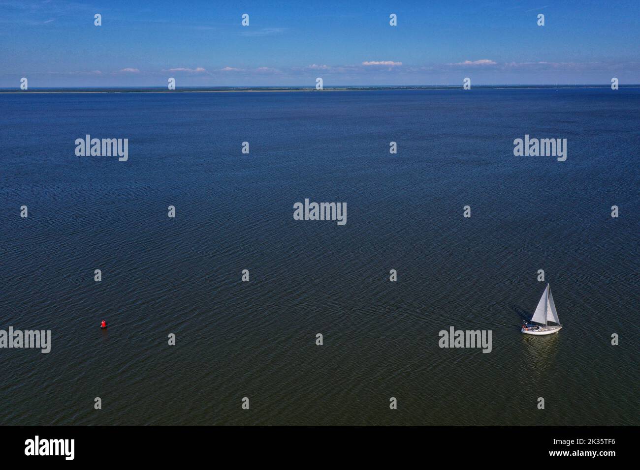 Yacht and red buoy on blue sea lagoon water, aerial view, Lithuania Stock Photo