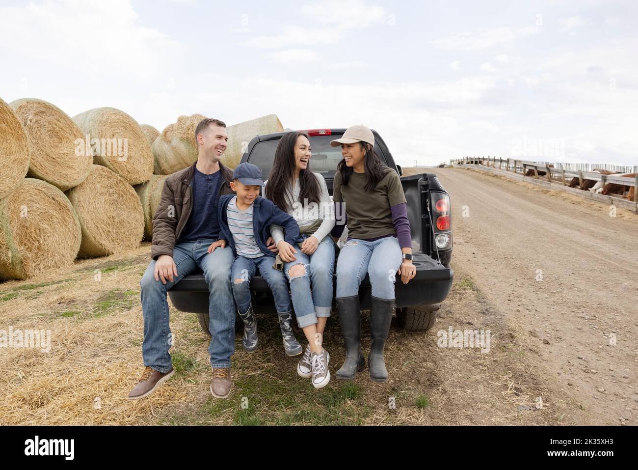 Happy farmer family at pickup truck tailgate on rural farm Stock Photo