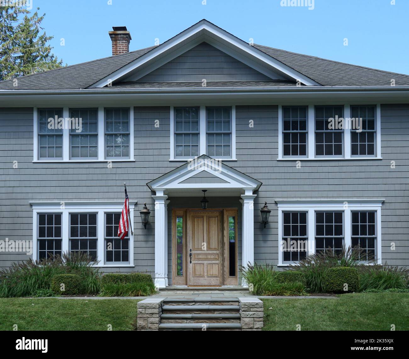 Front  of traditional two story suburban clapboard house with portico entrance Stock Photo