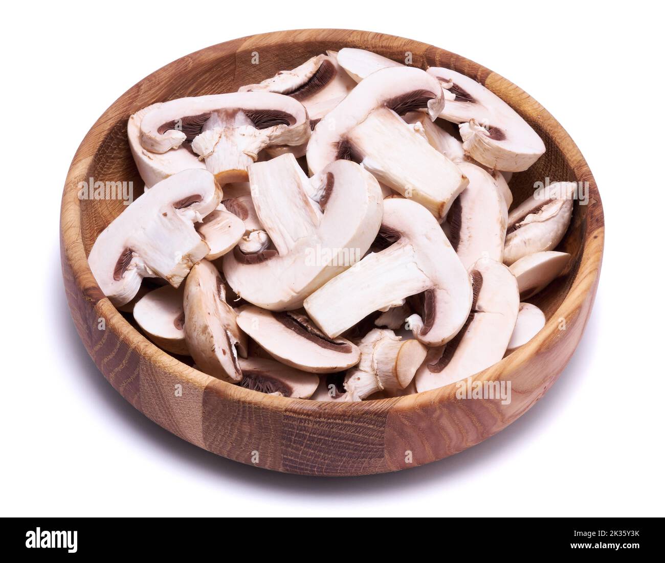 Sliced white champignon mushrooms in wooden bowl isolated on white background Stock Photo