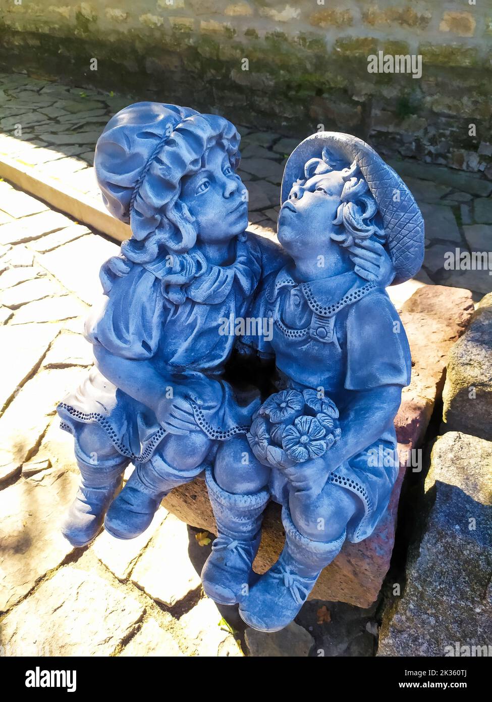Profiles of kissing children in park in Kamianets-Podilskyi Ukraine. Sculpture in the park with blue kissing boy and girl. Statue with cute couple kis Stock Photo