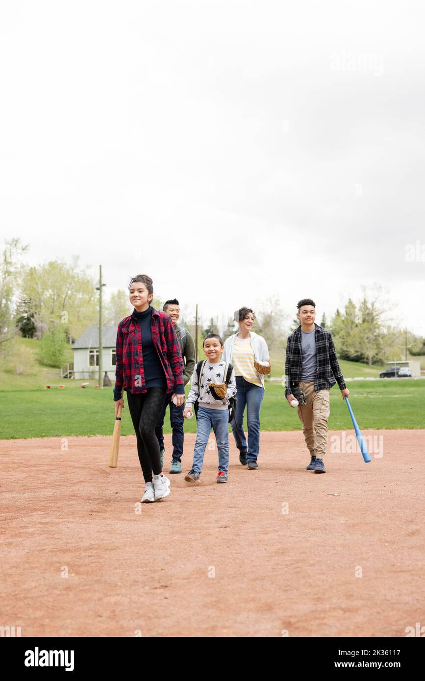 Cheerful family walking on baseball field Stock Photo Alamy