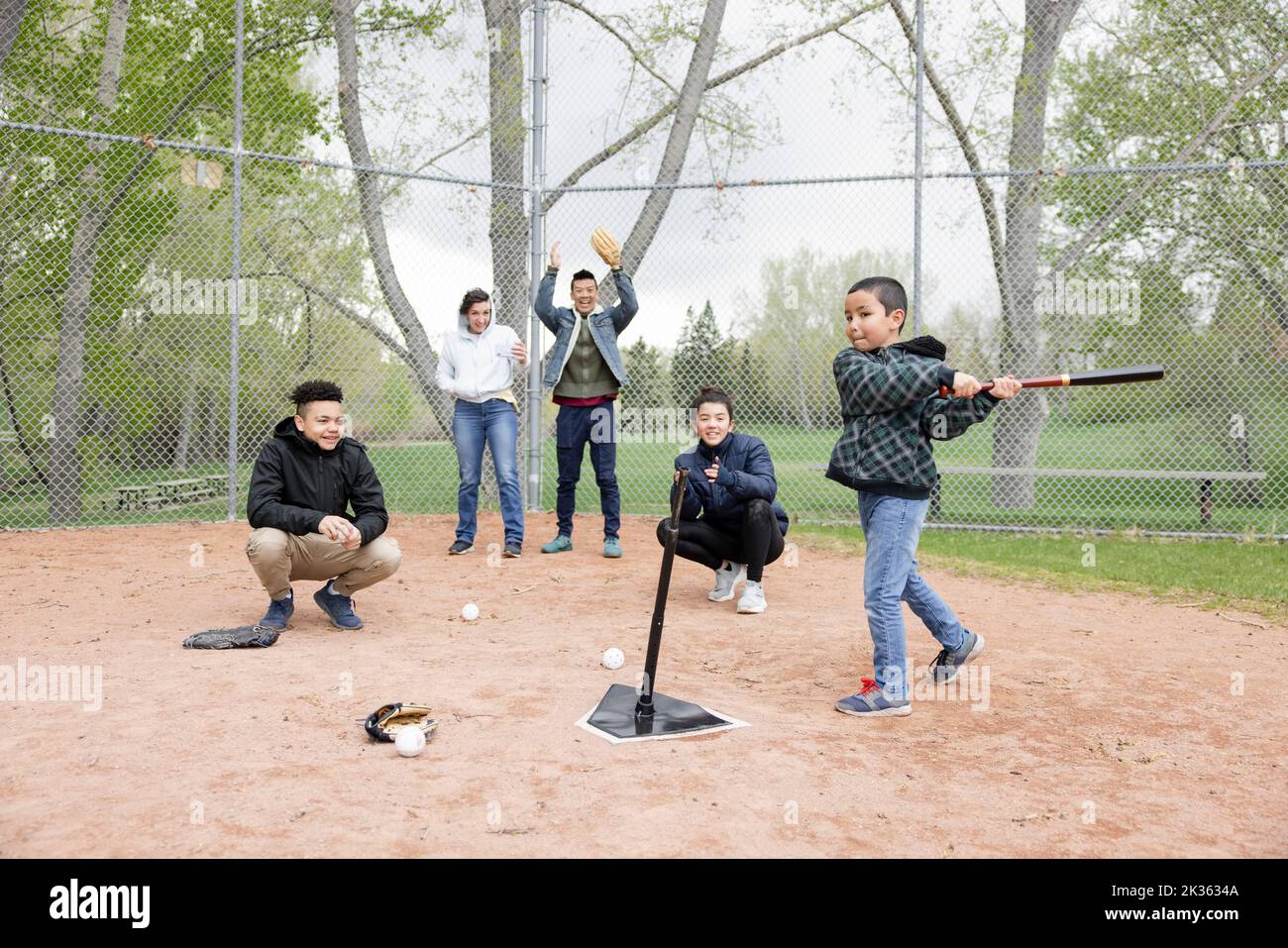 Boy swinging baseball bat on field Stock Photo Alamy