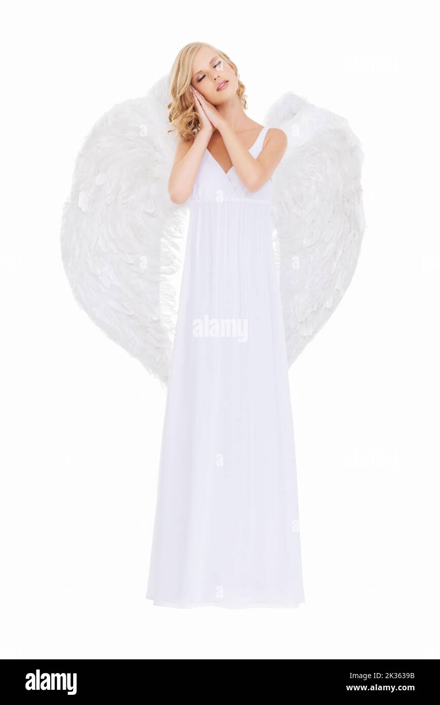 Sweetly innocent. Studio shot of a young woman in angel wings isolated on white. Stock Photo