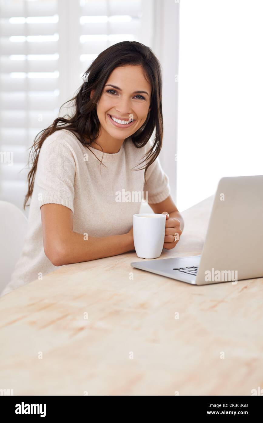 Enjoying the internet and all its freedom. Portrait of an attractive young woman using her laptop at home. Stock Photo