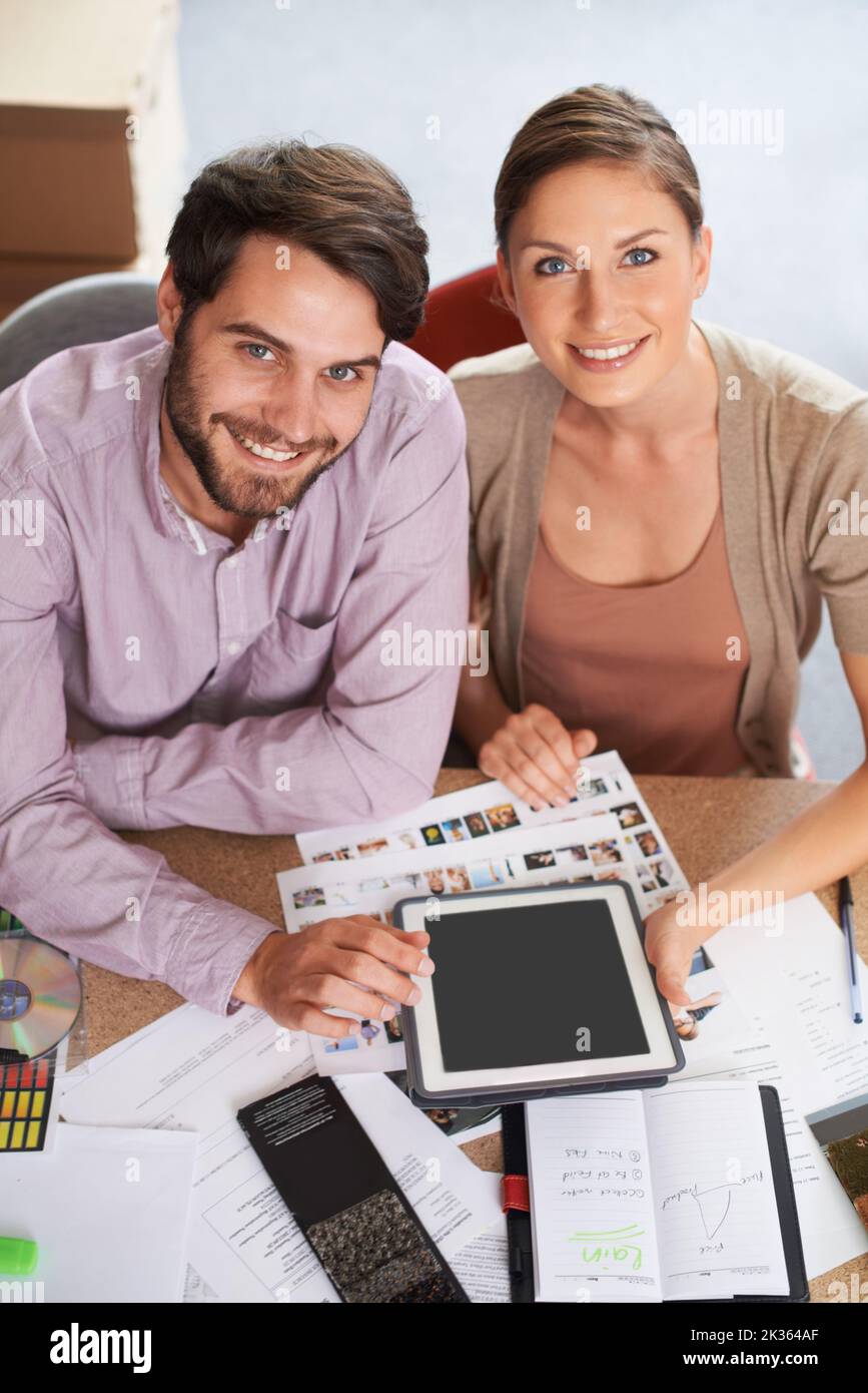 Now you can submit your designs online. young design professionals using a digital tablet while editing images. Stock Photo
